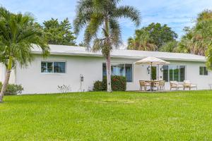 ein weißes Haus mit Palmen im Hof in der Unterkunft Jensen Beach Indian River Waterfront Retreat in Eden