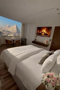 a bedroom with a large white bed with a fireplace at Lotus signature hotel in Cairo