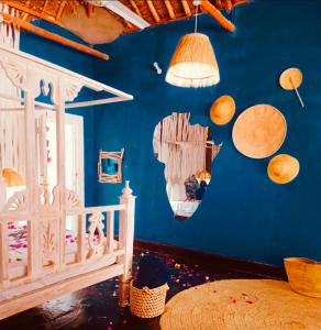een kamer met een blauwe muur, een bed en wat houten voorwerpen bij Richland makuti villas watamu in Watamu