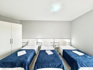 due letti in una stanza con lenzuola blu di Hotel Beach Canasvieiras a Florianópolis