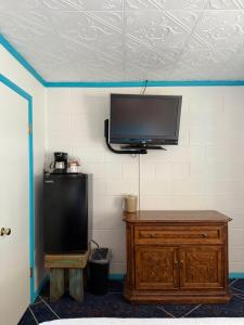 a flat screen tv hanging on a wall at Arrowhead Motel and RV Park in Ruidoso +40 photos