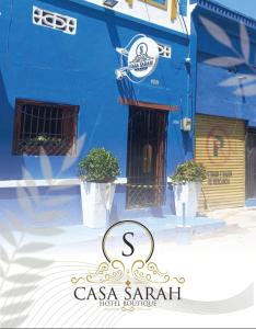 un edificio blu con due piante in vaso davanti di Hotel Casa de Sarah a Santa Marta