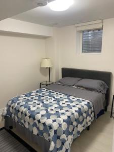 ein Schlafzimmer mit einem Bett mit einer blau-weißen Bettdecke in der Unterkunft Akhtar's Residence in Mississauga