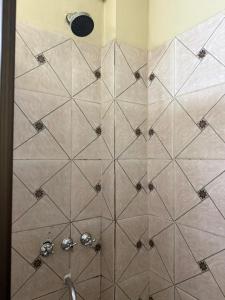 a shower with a tiled wall with a shower at Apart Centro CDE in Ciudad del Este +18 photos