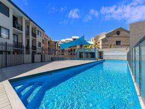 a large blue swimming pool in front of a building at 1BR Stylish Suite on Hay St in Perth