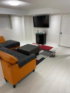 ein Wohnzimmer mit Sofa und Flachbildfernseher in der Unterkunft Akhtar's Residence in Mississauga