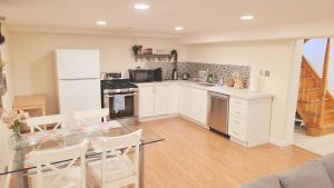 een keuken met witte kasten en een glazen tafel bij Richview Gardens Apartment in Toronto