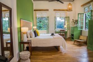 ein Schlafzimmer mit einem Bett in einem Zimmer mit grünen Wänden in der Unterkunft Baan Samsa in Luang Prabang