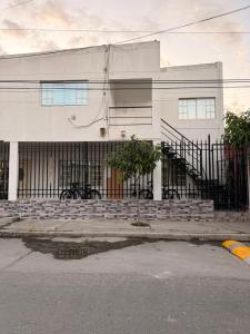 a white building with a fence in front of it at Apartamento completo in Santa Marta +1 photo