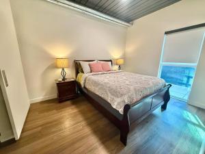 a bedroom with a bed with two lamps and a window at Luxury Central City Escape in Salt Lake City +25 photos