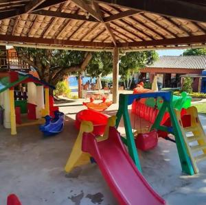 un parco giochi con scivoli colorati e un tavolo di Suite com jacuzzi privativa a Maceió