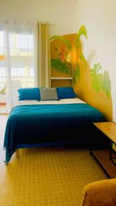 a bedroom with a bed with a painting on the wall at Mozaïka - Le cocon tropical in Pointe-à-Pitre