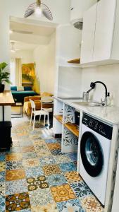 a kitchen with a washing machine on a tile floor at Mozaïka - Le cocon tropical in Pointe-à-Pitre +27 photos