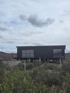 una casa nera seduta in cima a una collina di Altos Dique Potrerillos a Potrerillos Altre 4 foto