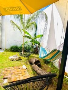 een hangmat en een stoel onder een paraplu bij Loft Industrial Petfriendly in Tlaxcala de Xicohténcatl