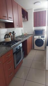 een keuken met houten kasten en een kookplaat met oven bij Departamento Centro de Viña in Viña del Mar