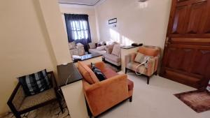 a living room with couches and chairs and a door at Honey house in Marrakesh