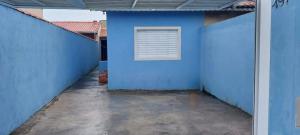een blauwe muur met een raam in een binnenplaats bij Casa Ilha comprida 2 quartos yemar in Ilha Comprida +3 foto's