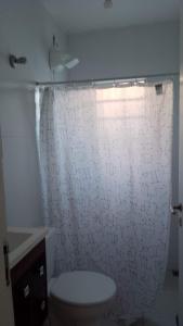 a bathroom with a toilet and a white wall at Casa Ilha comprida 2 quartos yemar in Ilha Comprida