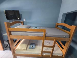 a bunk bed with a tv on top of it at Pousada Hostel Beach Pajuçara in Maceió