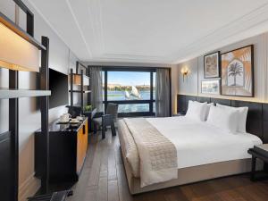 a hotel room with a large bed and a window at Mövenpick MS Sunray in Luxor +100 photos