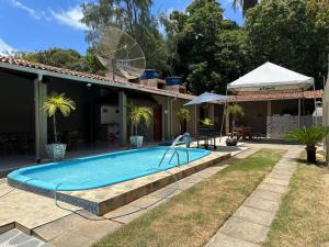 a swimming pool in a yard next to a house at Casa Aiyra in São Miguel dos Milagres