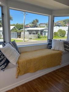 a window seat with a view of a street at Wee Blue Bach at Waihi Beach in Waihi Beach