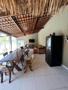 a large room with a table and a refrigerator at Casa Aiyra in São Miguel dos Milagres