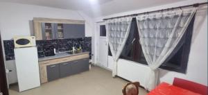 una cucina con lavandino e una finestra con tende di Remetea 292 a Remetea