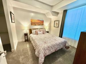 a bedroom with a bed and a large window at Spacious 2-Bedroom Urban Oasis in Salt Lake City