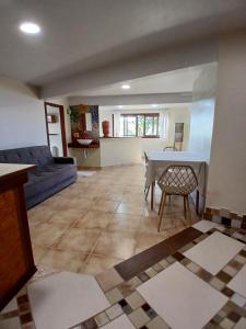 un soggiorno con un tavolo e un divano di Casinha de Hobbit a Florianópolis