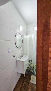 a white bathroom with a sink and a mirror at La Soñada - cabañas in Cruz del Eje