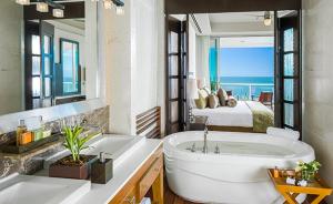 een badkamer met een groot bad en een slaapkamer bij Vidanta 2-bdrm Villa, in Nuevo Vallarta 