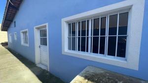 een blauw gebouw met een raam en een deur bij Casa Ilha comprida 2 quartos yemar in Ilha Comprida