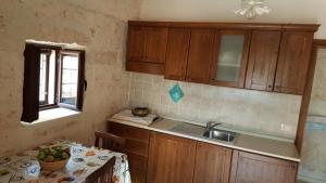 uma cozinha com um lavatório, uma mesa e uma janela em Casale Valle degli Ulivi em Ostuni