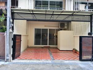 an open garage with a refrigerator in front of a building at Chotam 2 bedroom flat Townhouse in Nathon Bay
