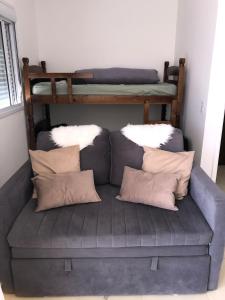 een bank met kussens en een stapelbed in een kamer bij Beachfront apartment with swimming pool in Mongaguá +56 foto's