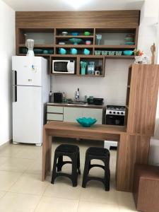 een keuken met een tafel en stoelen en een koelkast bij Beachfront apartment with swimming pool in Mongaguá