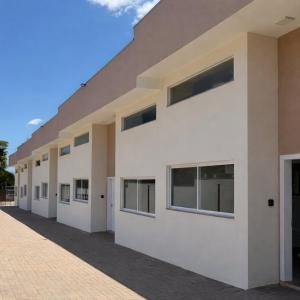 a white building with windows on a brick street at Cataratas Loft Residence in Foz do Iguaçu