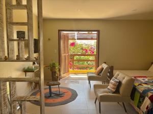 a bedroom with a bed and chairs and a window at Quintal da Espera - Praia de Itacimirim in Camacari