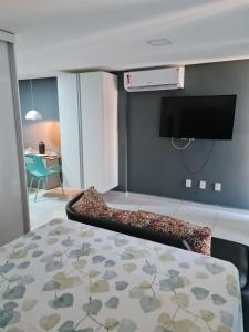 ein Schlafzimmer mit Bett und Flachbildfernseher in der Unterkunft Conforto e sofisticação em Ponta de Campina in Cabedelo + 6 Fotos