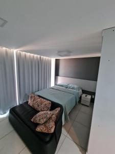 ein Schlafzimmer mit einem Bett und einer Couch in der Unterkunft Conforto e sofisticação em Ponta de Campina in Cabedelo