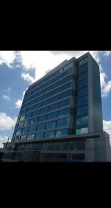 ein hohes Glasgebäude mit vielen Fenstern in der Unterkunft Conforto e sofisticação em Ponta de Campina in Cabedelo