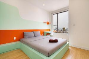una camera da letto con un letto con una parete arancione di Citizen apartment - rivergate ad Ho Chi Minh