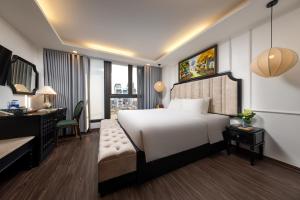 een slaapkamer met een groot wit bed en een bureau bij Golden Legend Palace Hotel & Travel in Hanoi