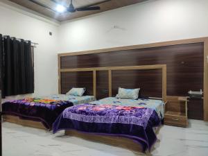 two beds sitting next to each other in a room at Naval Kishori Kunj in Vrindāvan