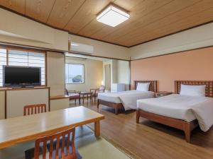 Zimmer mit 2 Betten, einem Tisch und einem TV in der Unterkunft Toba Wan Wan Paradise Hotel in Toba + 71 Fotos