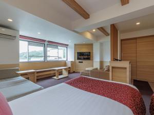 ein Hotelzimmer mit Bett und Schreibtisch in der Unterkunft Toba Wan Wan Paradise Hotel in Toba