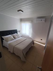 una camera da letto con un letto e una finestra di Luluk, Casa de playa a Balneario Pehuén-Có Altre 26 foto