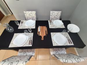 a table with three plates and a phone on it at Luluk, Casa de playa in Balneario Pehuén-Có